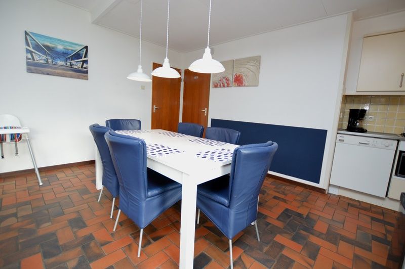 Dining area in Orchismient 18 large vacation home, De Koog, Texel with comfortable chairs and modern table.