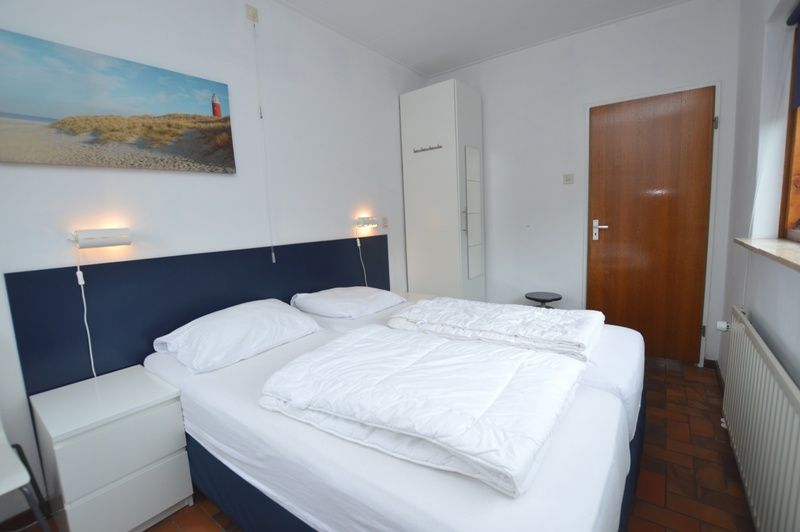 Bedroom with double bed in Orchismient 18 large vacation home, De Koog, Texel with relaxing atmosphere.