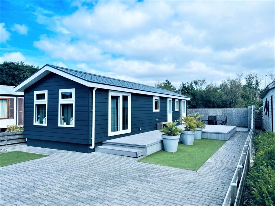 Chalet Bregkoog 215 Zandhuisjes op Chaletpark Bregkoog in De Koog, Texel biedt een moderne buitenkant en ruime veranda.