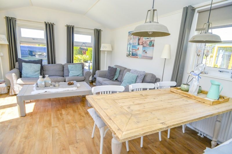 Gezellige woonkamer in Chalet Bregkoog 215 Zandhuisjes, Chaletpark Bregkoog, De Koog, Texel met comfortabele banken en houten vloer.