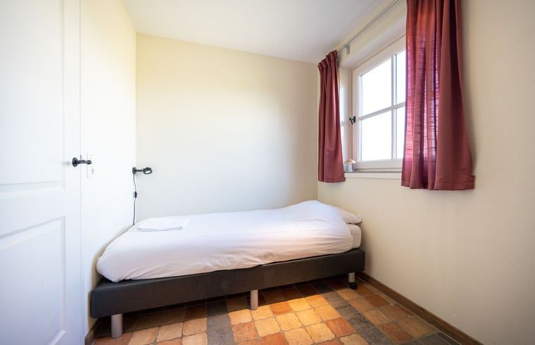Cozy single room at Huisje in De Waal, Texel with warm tones and natural light.