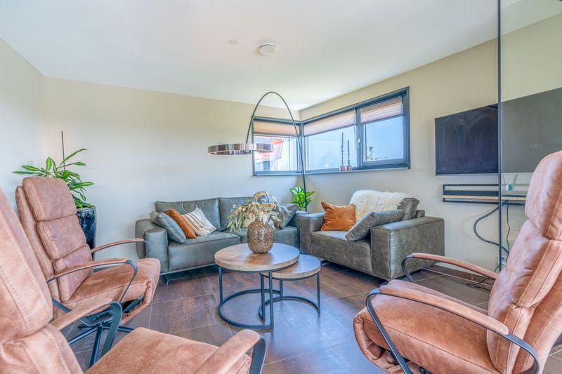 Stylish living room of Villa 18 Waswaal, De Waal, Texel offers a cozy atmosphere with comfortable seating.