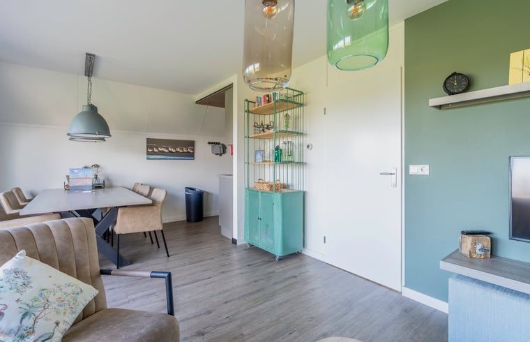 Stylish dining room in Holiday home in De Waal, Texel with designer chairs and decorative elements.