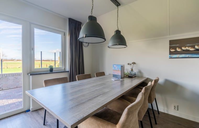 Dining area in Holiday home in De Waal, Texel with spacious table and comfortable chairs.