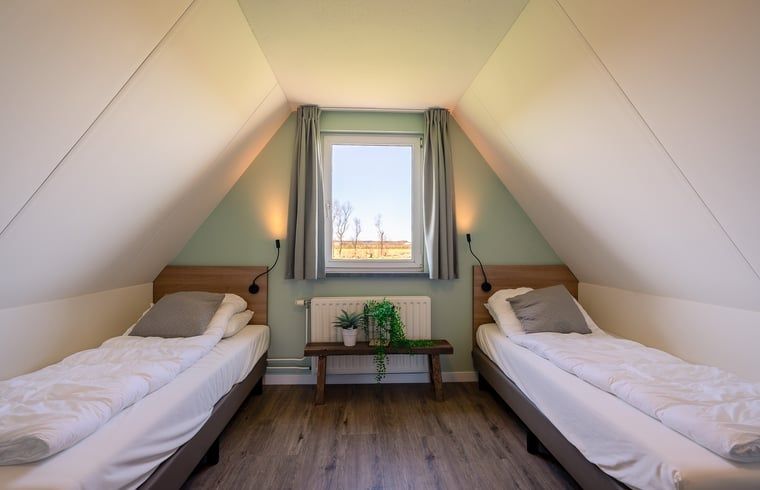 Bedroom with two single beds in Holiday home in De Waal, Texel overlooking the countryside.