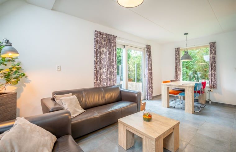 Moderne leefruimte in Huisje in De Waal, Texel met openslaande deuren naar het terras.