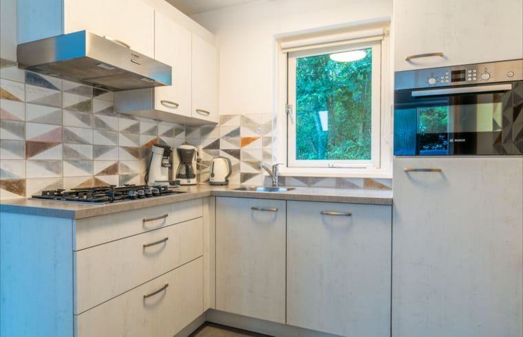 Volledig uitgeruste keuken in Huisje in De Waal, Texel met moderne apparatuur en uitzicht op de natuur.