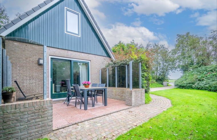 Terras van Huisje in De Waal, Texel met tuinmeubilair, ideaal voor buiten dineren.