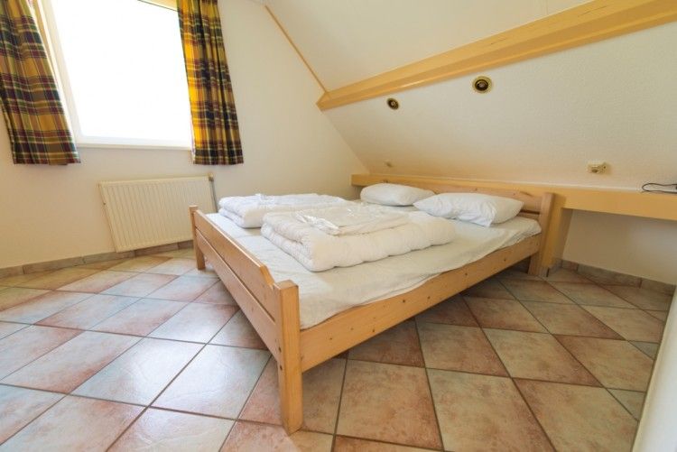 Schlafzimmer im Bungalow De Boogerd, De Waal, Texel mit komfortablem Doppelbett und beruhigender Atmosphre fr eine gute Nachtruhe.