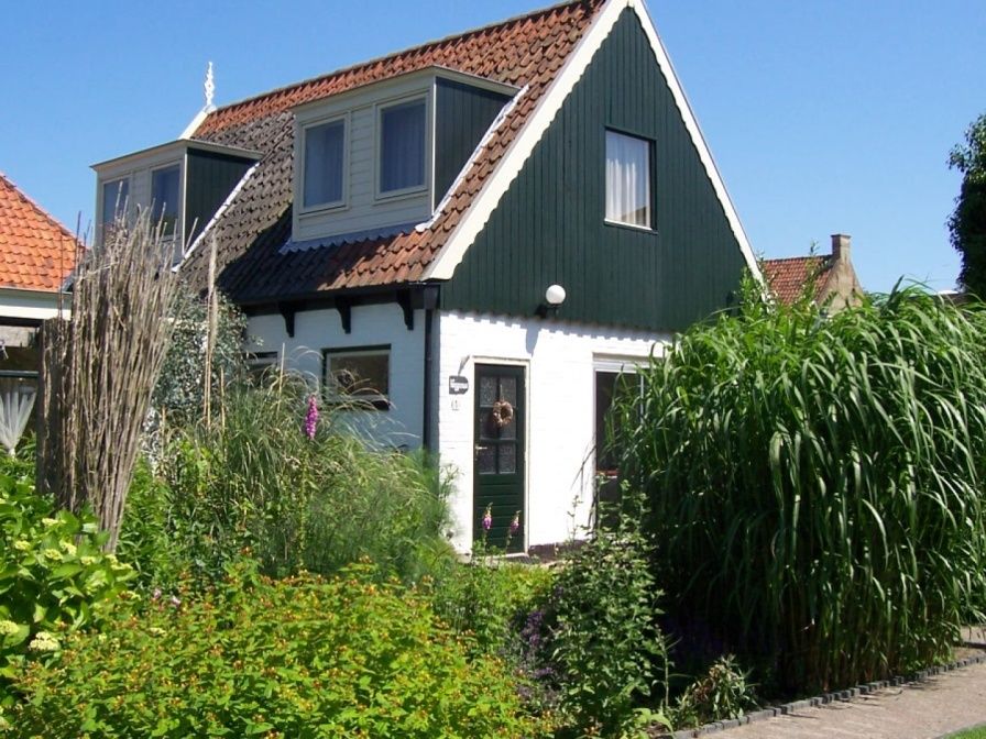 Vacation home De Heggemus in Den Burg, Texel with charming facade and green garden.