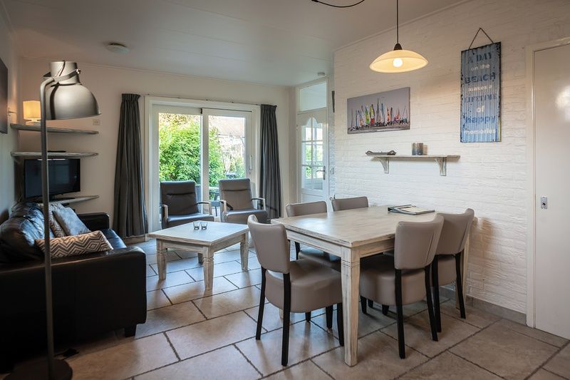 Spacious dining room in Holiday home De Heggemus, Den Burg, Texel overlooking the garden.