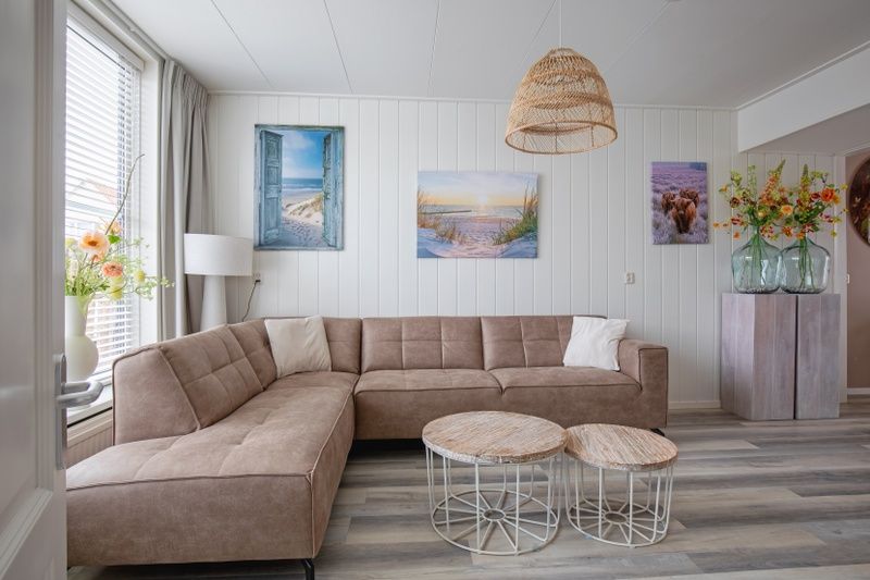 Gemuetliches Wohnzimmer von Schoonoord in Den Burg, Texel mit bequemem Sofa und Dekoration.