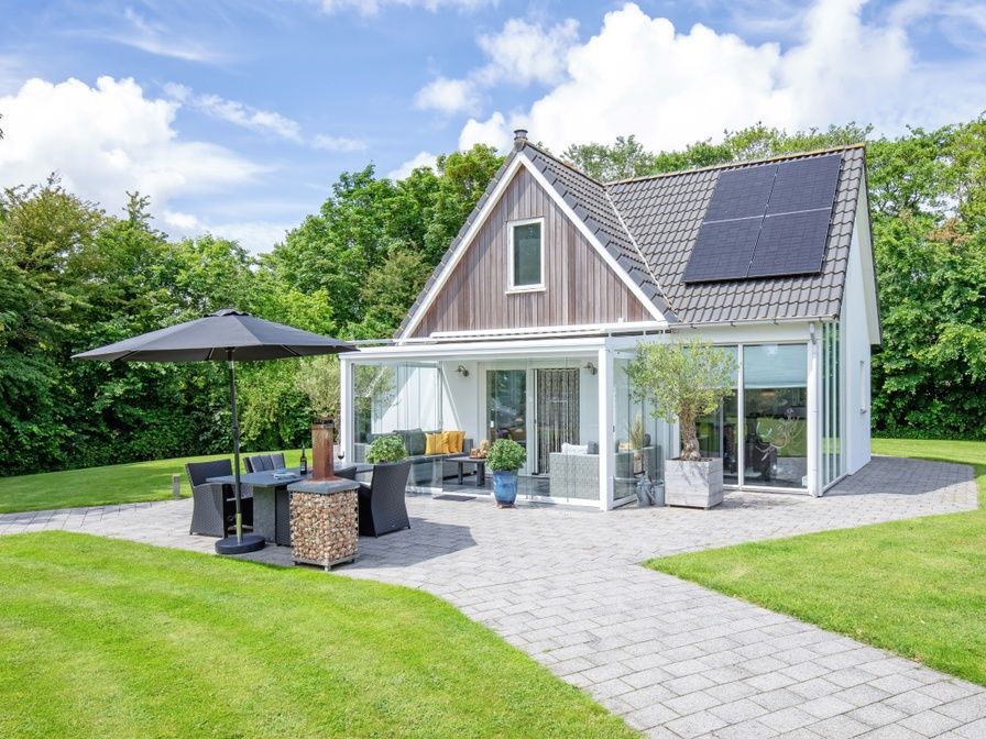 Vakantiehuis Uit Zicht in Den Burg, Texel met zonnig terras en groene tuin.