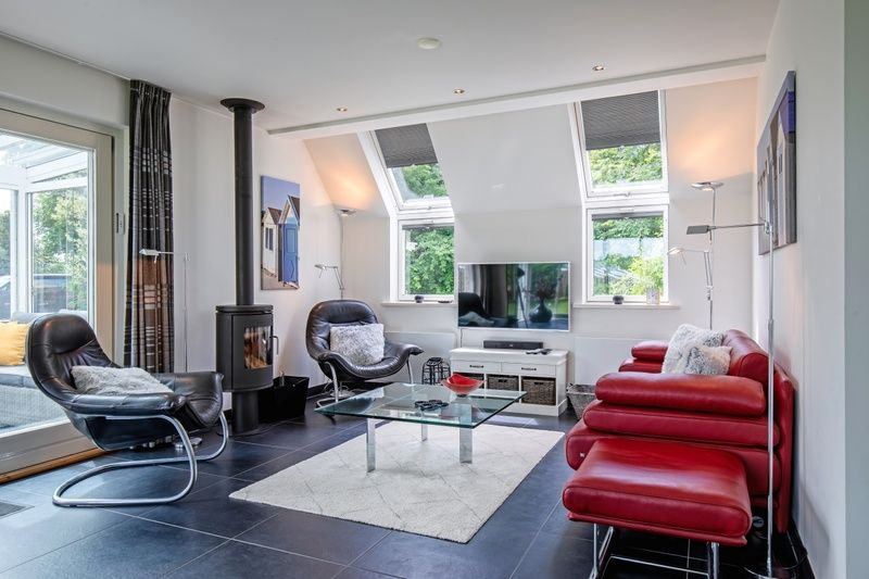 Moderne woonkamer van Uit Zicht in Den Burg, Texel met comfortabele zithoek.