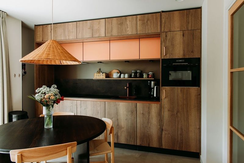 Moderne Kueche und Essbereich im Luxusappartement 4p, Den Burg, Texel mit Holzverkleidung und Rattanlampe.