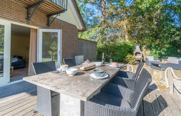 Zonnig terras in Huisje in Den Burg, Texel met comfortabele zitplaatsen voor buitenmaaltijden.