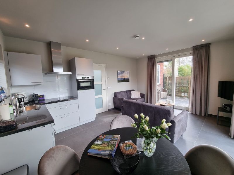 Modernes Wohnzimmer mit offener Kueche im Ferienhaus Schoonoordsingel 29a, Den Burg, Texel.