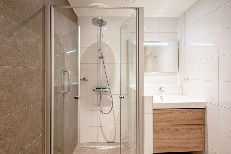 Stilvolle Dusche und Waschbecken im Appartement Gouden Reaal 25, Den Hoorn Texel fuer hoechsten Komfort.
