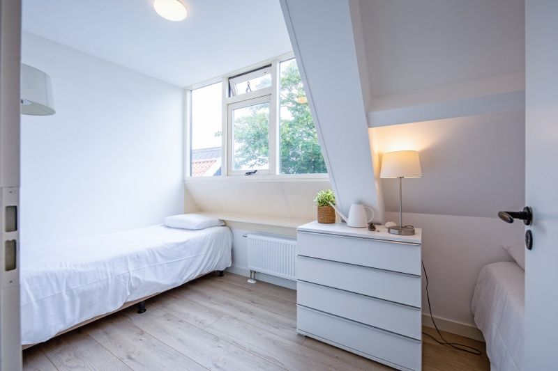 Helles Schlafzimmer mit Einzelbett im Hotel Loodsmans Welvaren - Apartment, Den Hoorn, Texel.