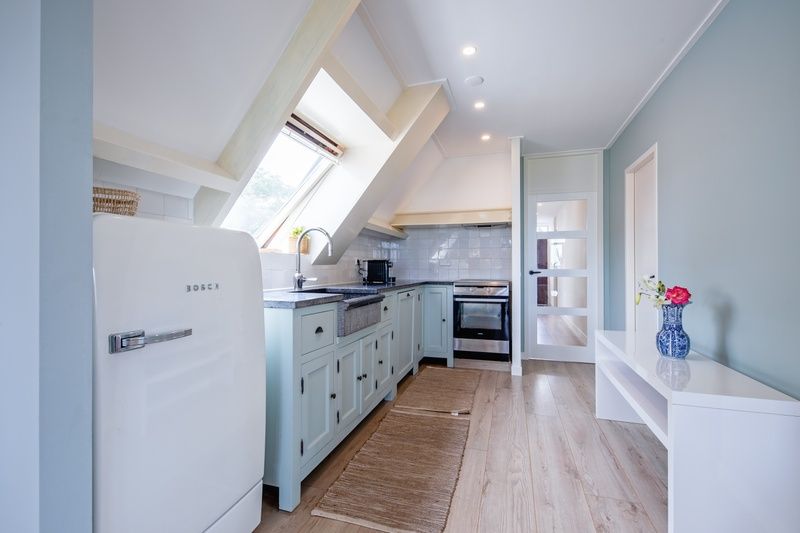 Vollstaendig ausgestattete Kueche im Hotel Loodsmans Welvaren - Apartment, Den Hoorn, Texel mit modernen Annehmlichkeiten.