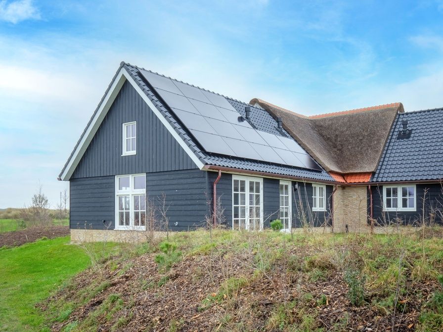 Ferienhaus Kamille in Den Hoorn, Texel, mit moderner Architektur und Sonnenkollektoren, umgeben von der ruhigen Natur der Watteninseln.