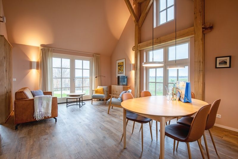 Gemuetliches Wohnzimmer im Ferienhaus Kamille in Den Hoorn auf Texel mit Holzinterieur und Blick auf die Natur der Watteninseln.