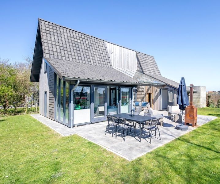 Uitzicht op TexelZon vakantiehuis in Den Hoorn met zonnig terras en tuin.