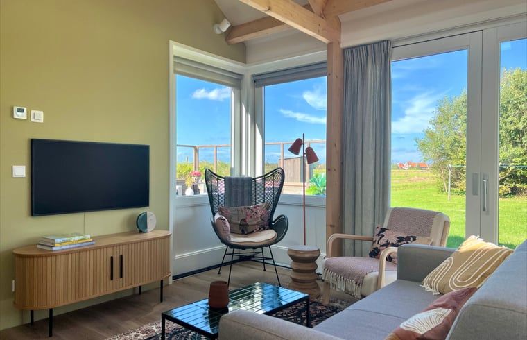 Gemuetliche Sitzecke im Ferienhaus in Den Hoorn, Texel, mit Blick auf die Natur.