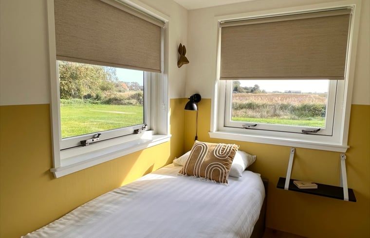 Schlafzimmer mit Einzelbett im Ferienhaus in Den Hoorn, Texel, mit Blick auf den Garten.