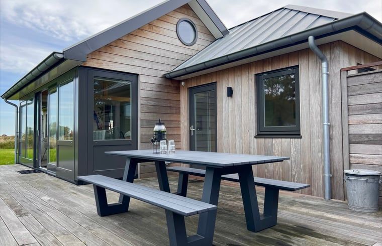 Picknicktisch auf der Holzterrasse des Ferienhauses in Den Hoorn, Texel.