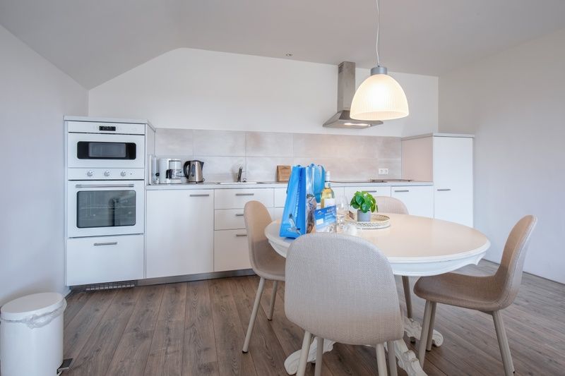 Moderne Kueche im Ferienhaus Grietje, Den Hoorn, Texel mit Esstisch und stilvollen Geraeten.