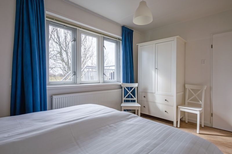Schlafzimmer im Ferienhaus Grietje, Den Hoorn, Texel mit Blick auf die Umgebung und geraeumigem Kleiderschrank.