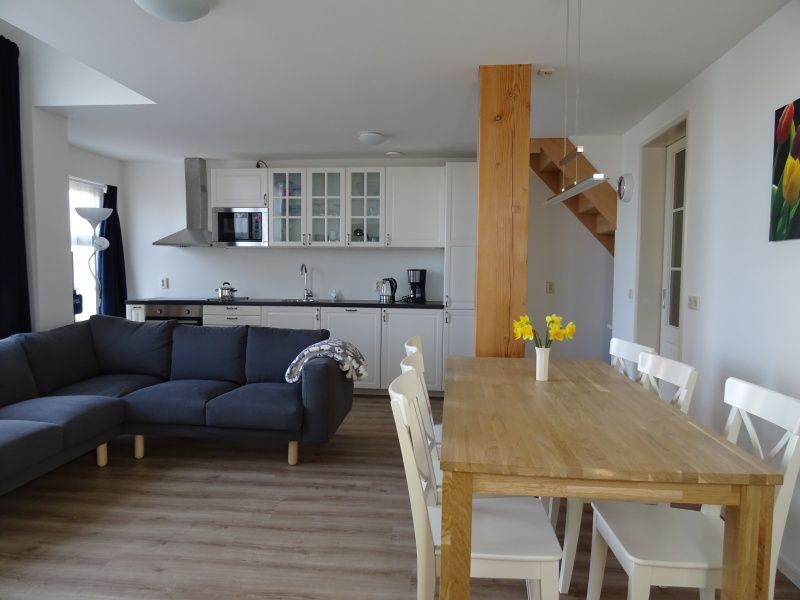 Moderne Kueche und Esszimmer in De Dors Ferienhaus Den Hoorn Texel fuer gemuetliches Beisammensein.