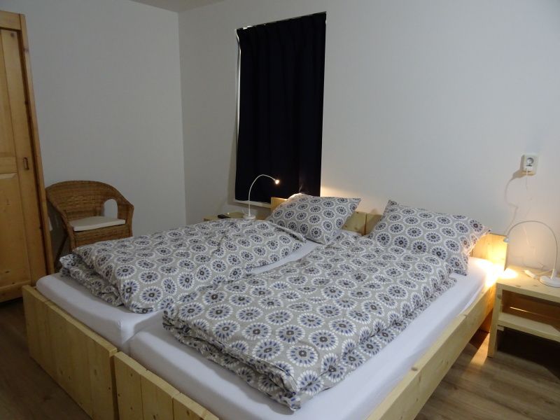 Gemuetliches Schlafzimmer im De Dors Ferienhaus Den Hoorn Texel mit Holzmoebeln.