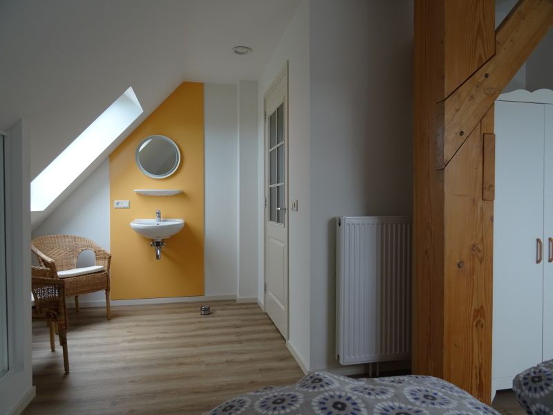 Stilvolle Ecke mit Waschbecken in De Dors Ferienhaus Den Hoorn Texel mit Holzdetails.