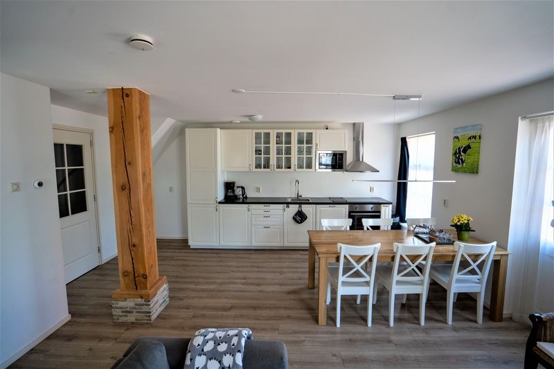Offene Kueche und Essbereich in De Dors Ferienhaus Den Hoorn Texel mit modernen Annehmlichkeiten.