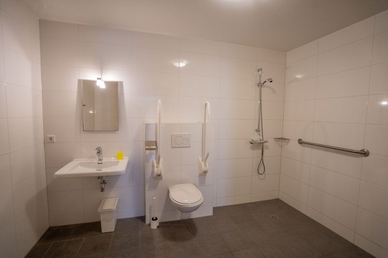 Rollstuhlgerechtes Badezimmer in De Dors Ferienhaus Den Hoorn Texel mit moderner Ausstattung.