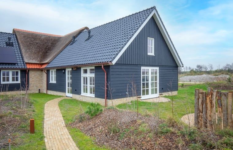 Huisje in Den Hoorn, een charmant vakantiehuis op Texel, Waddeneilanden, omgeven door natuur en met een uitnodigend terras.