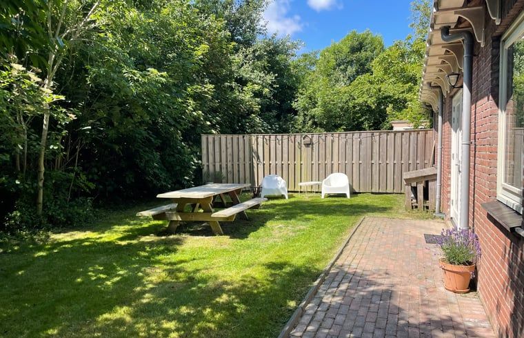 Veranda mit Sitzgelegenheiten im Garten des Ferienhauses in Oosterend Texel.