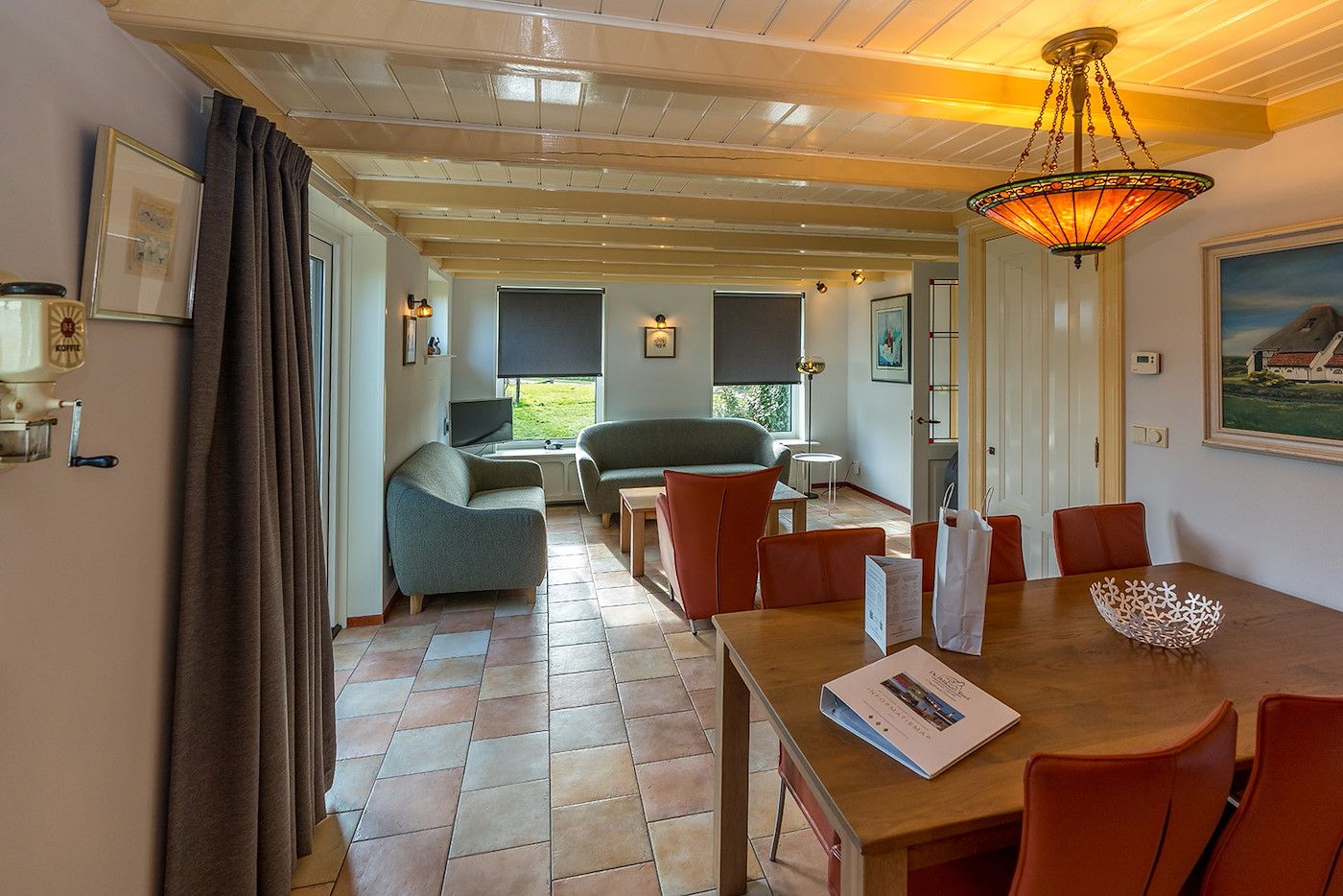 Gezellige woonkamer van Gouden Rijder vakantiehuis in Oosterend, Texel, met comfortabele banken en een eetgedeelte.