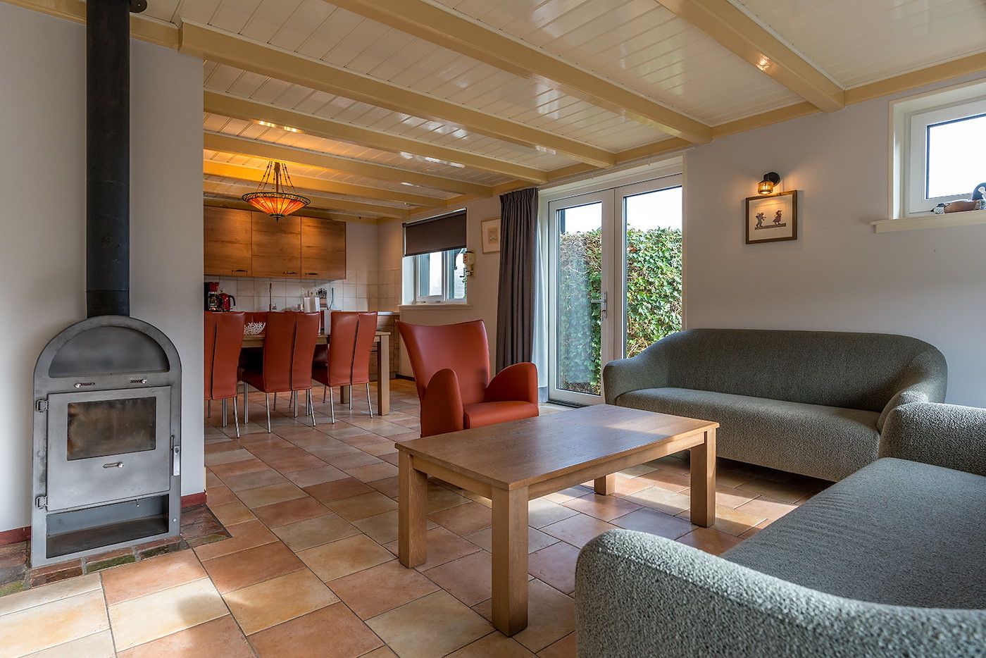 Open keuken en eetkamer in Gouden Rijder vakantiehuis, Oosterend, Texel, met een houtkachel voor extra sfeer.