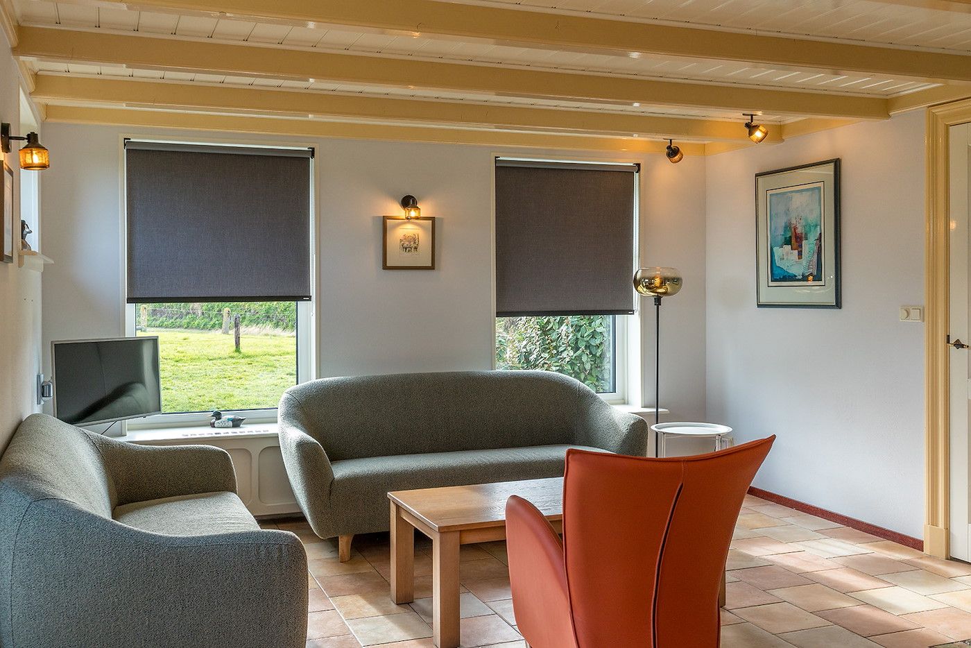 Lichte zithoek in Gouden Rijder vakantiehuis, Oosterend, Texel, met uitzicht op de tuin en moderne inrichting.
