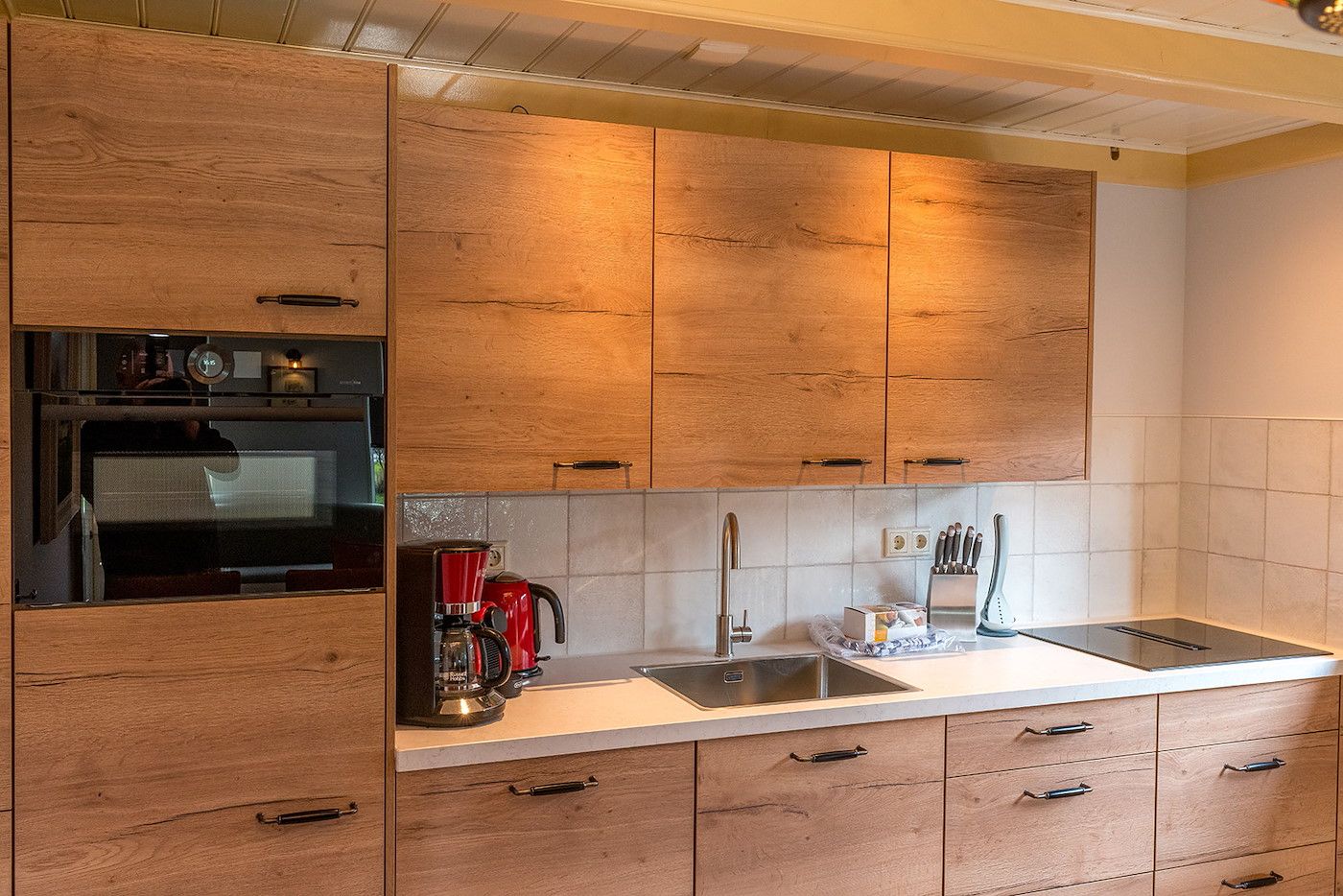Moderne keuken in Gouden Rijder vakantiehuis, Oosterend, Texel, met houten kasten en moderne apparatuur.