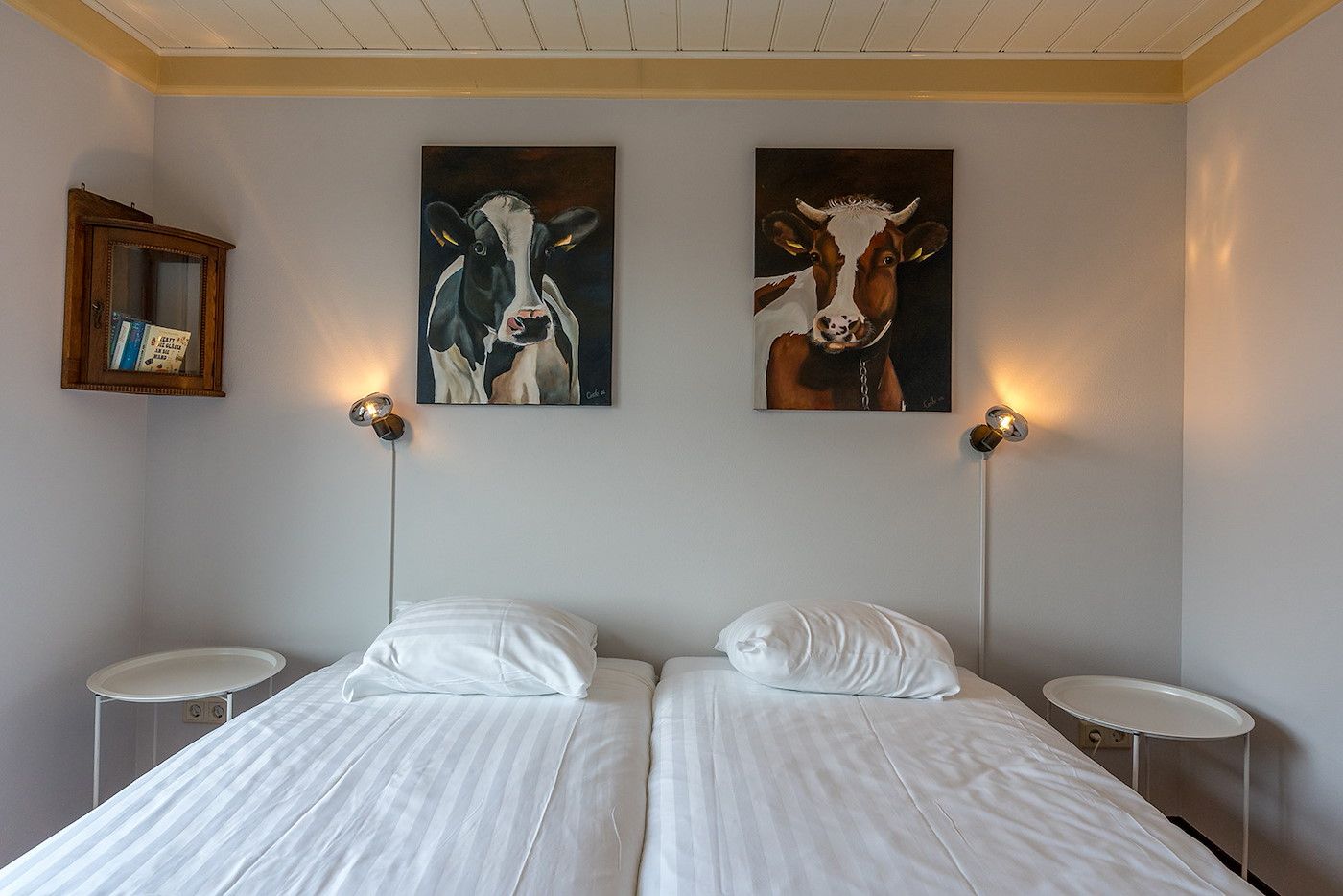Slaapkamer in Gouden Rijder vakantiehuis, Oosterend, Texel, met comfortabele bedden en kunst aan de muur.