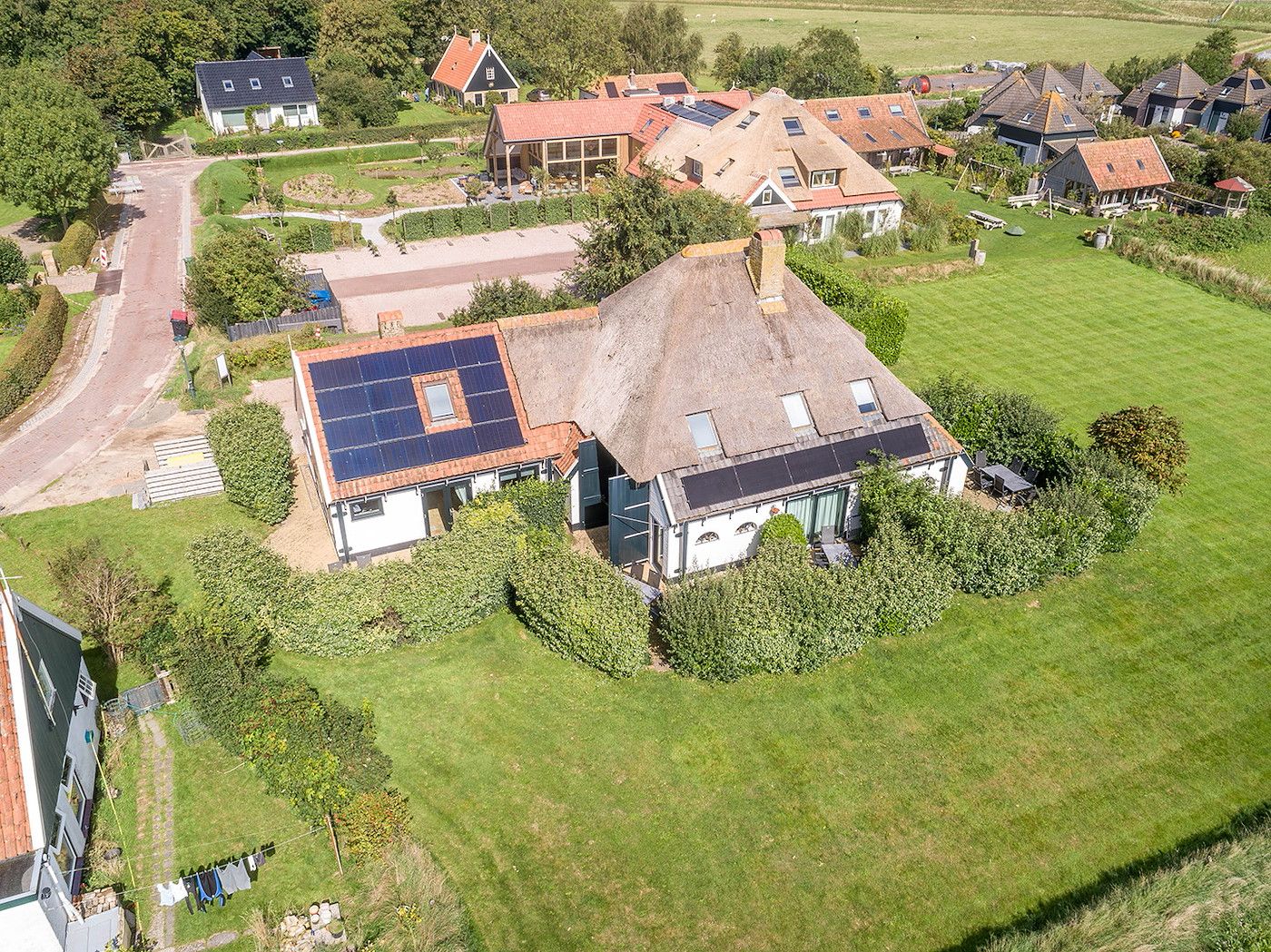Gouden Rijder vakantiehuis, Oosterend, Texel, vanuit de lucht, met uitzicht op omliggende huizen en tuinen.