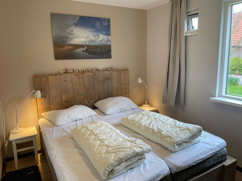 Lichte slaapkamer met twee bedden in Type II - nr. 47 Koolmees, vakantiehuis Oosterend, Texel.