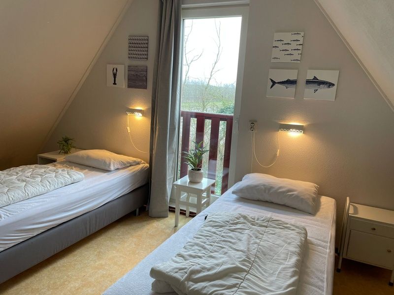 Zonnig terras met parasol in de tuin van Type II - nr. 47 Koolmees, vakantiehuis Oosterend, Texel.