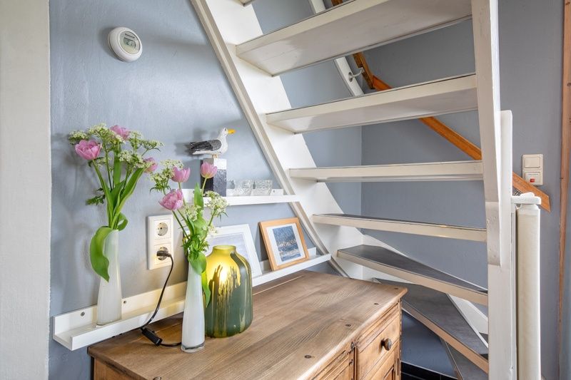 Trap en decoratie in vakantiehuis 't Raadsel in Oosterend Texel, sfeervol en uitnodigend.