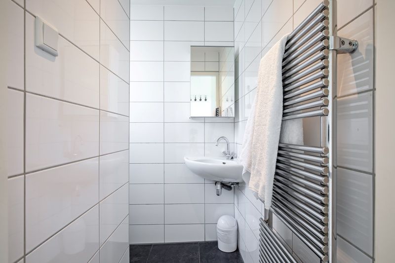 Stijlvolle badkamer van 't Raadsel in Oosterend Texel met wastafel en handdoekradiator.