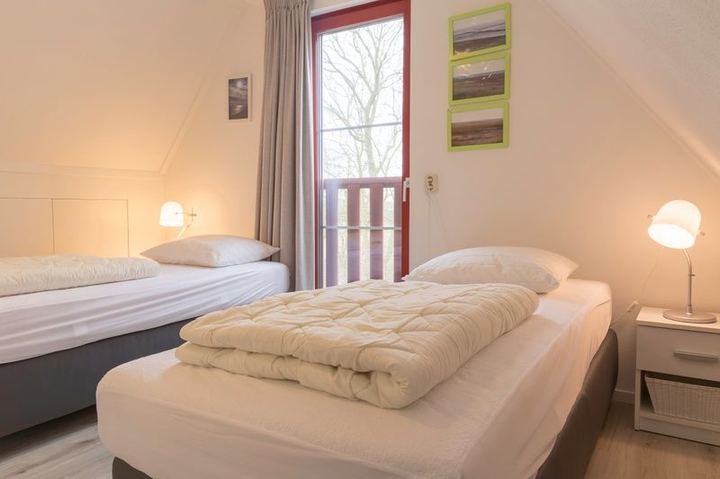 Spacious bedroom with balcony in Type I - No. 49 Kragenmaker, Oosterend Texel, vacation home on the Wadden Islands.